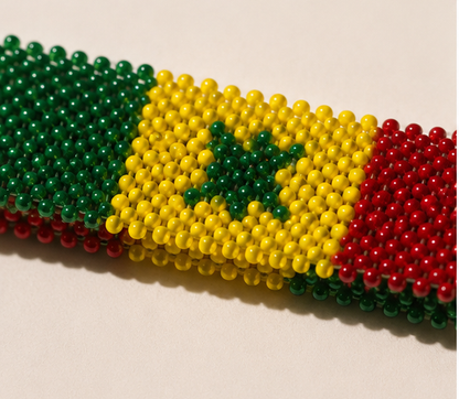 Close-up of handmade Senegal beaded bracelet showing green star and detailed beadwork